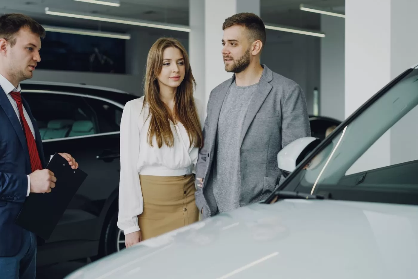 A salesperson walking a couple through the details of a vehicle deal in the showroom